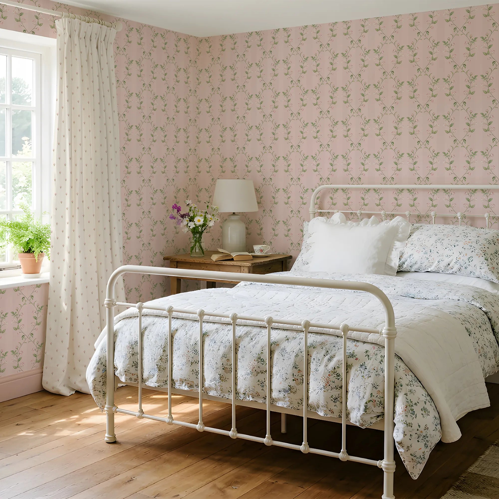 A bedroom with a pink floral wallpaper, white bed, and wooden flooring.