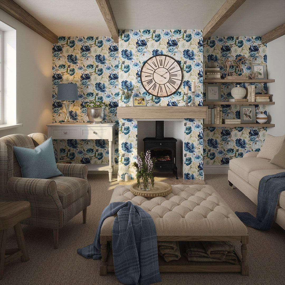 Cottage living room setting featuring soft furnishings and fabrics with a floral wallpaper in blues and creams. 