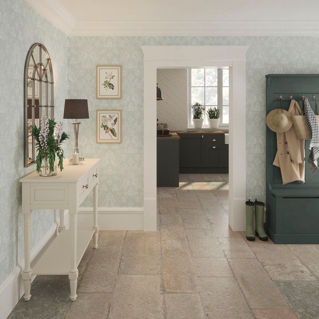 Cottage hallway setting with an entrance to the kitchen. Hallway features damask floral wallpaper in mint green.