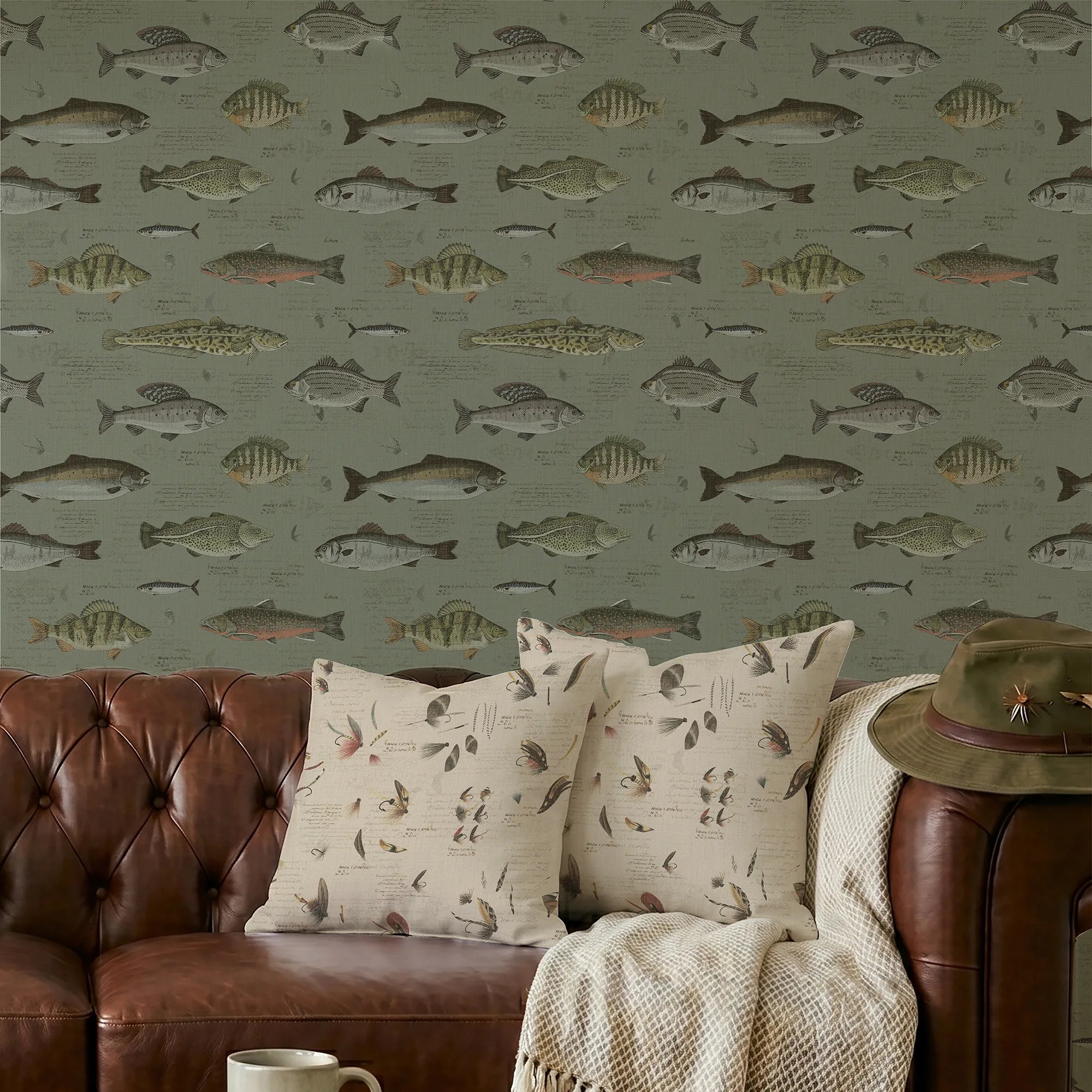 Wallpaper with fish pattern, a brown sofa with patterned cushions with a  hat, and a cup on a coffee table.