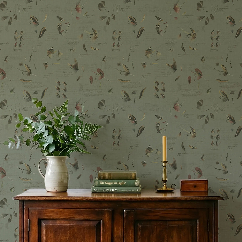 Decorative wallpaper with a fishing themed pattern, wooden cabinet with vase, books, and candle.