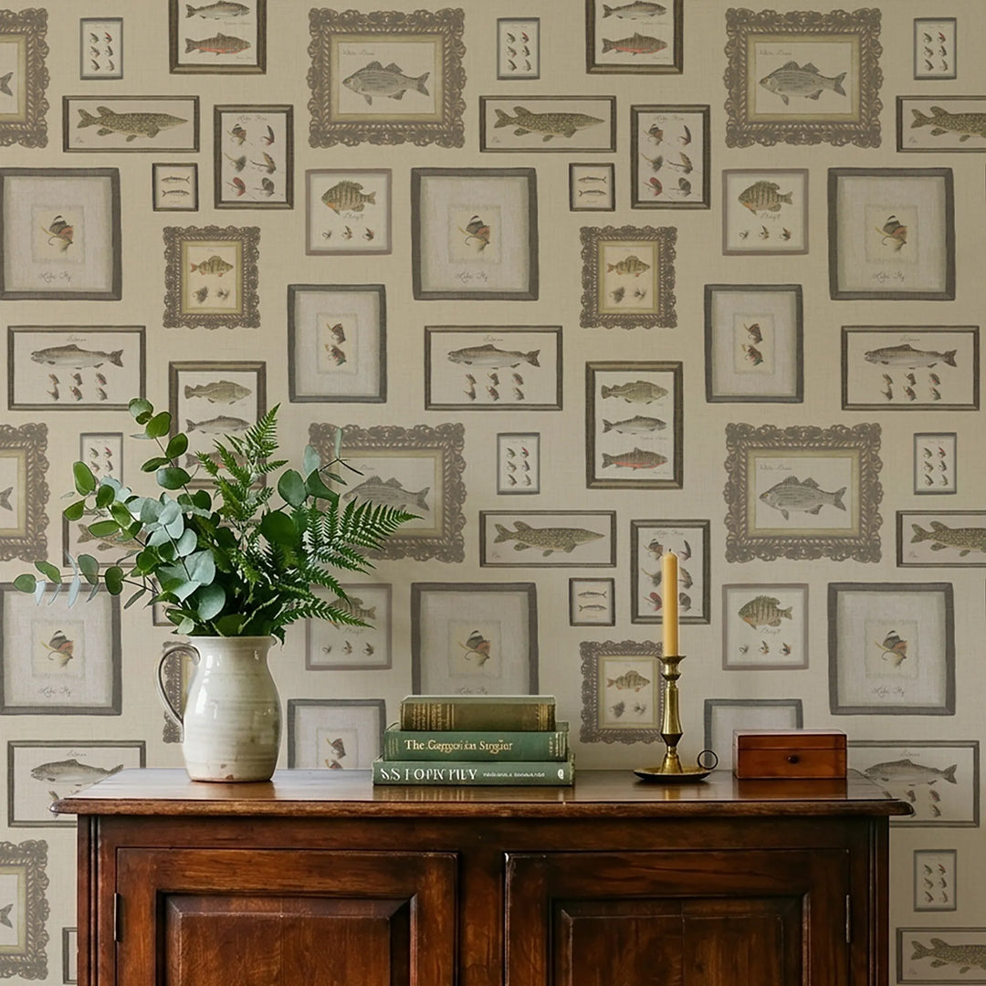 Wallpaper with framed fish illustrations, a wooden cabinet with books and a vase, and a candlestick.