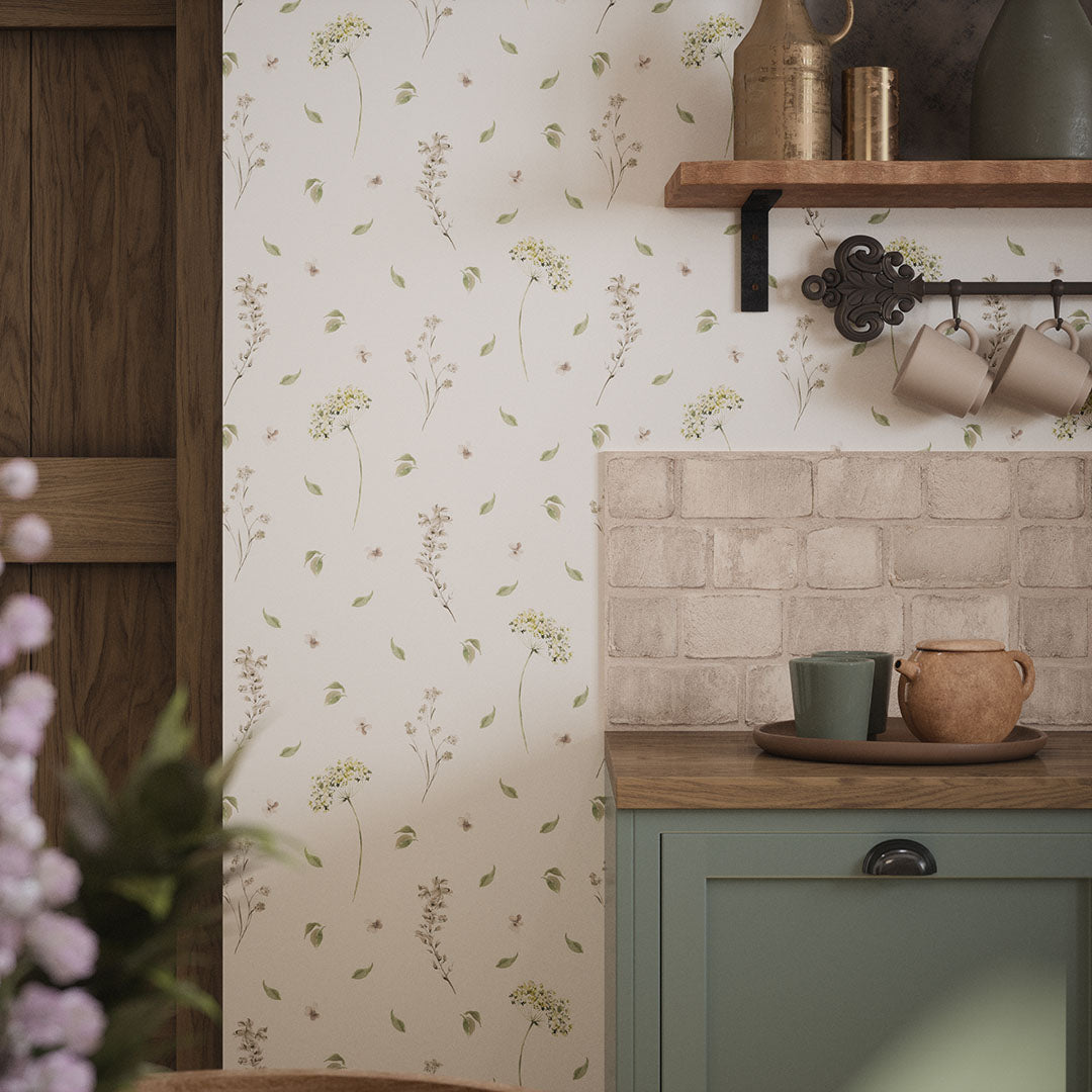 Kitchen setting with oak countertops, teacups and delicate floral wallpaper.
