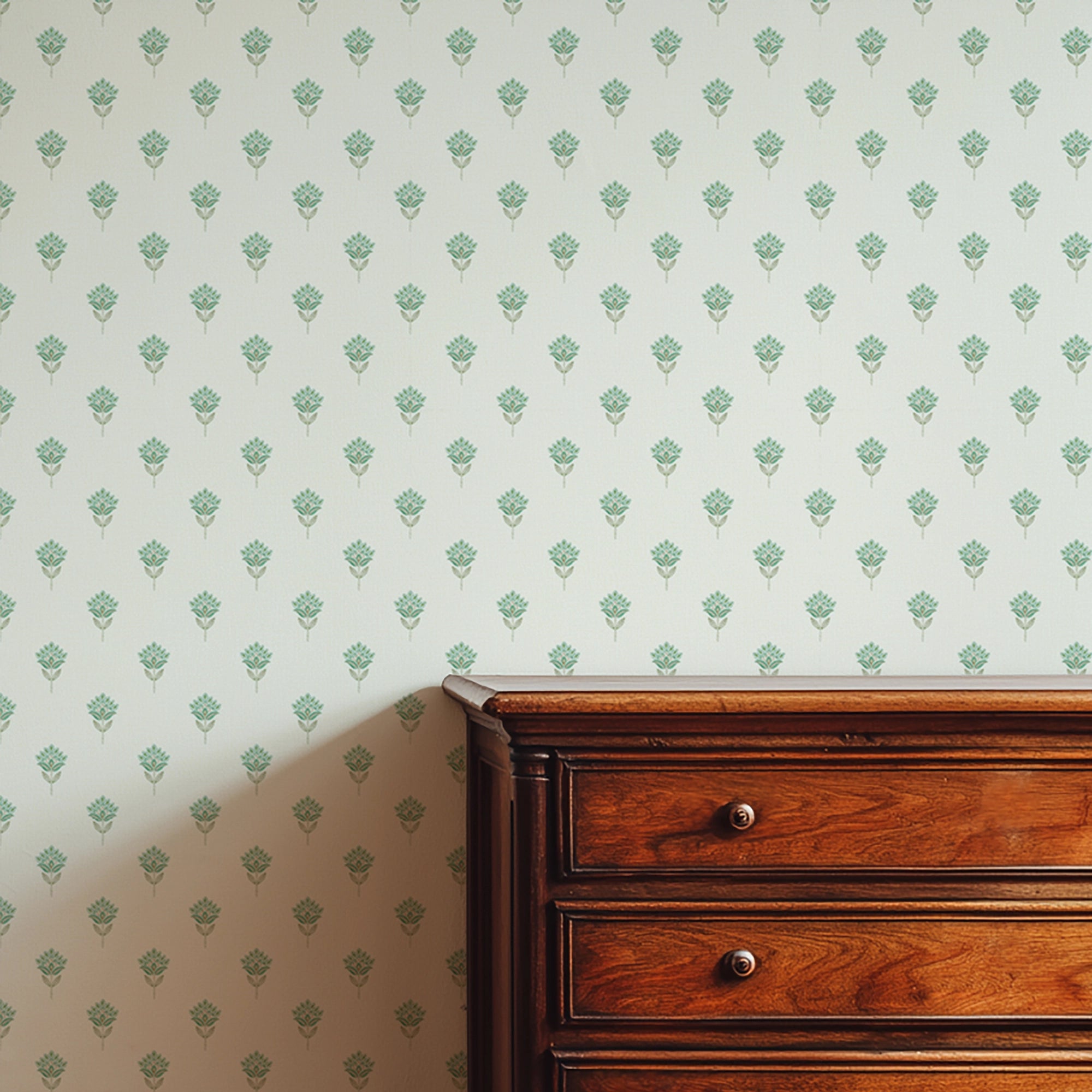Wooden dresser against a wall with a subtle floral pattern in blues and greens.