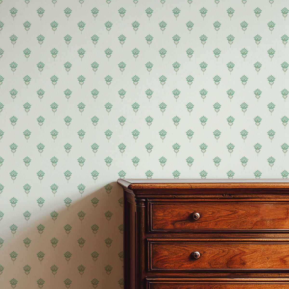 Wooden dresser against a wall with a subtle floral pattern in blues and greens.