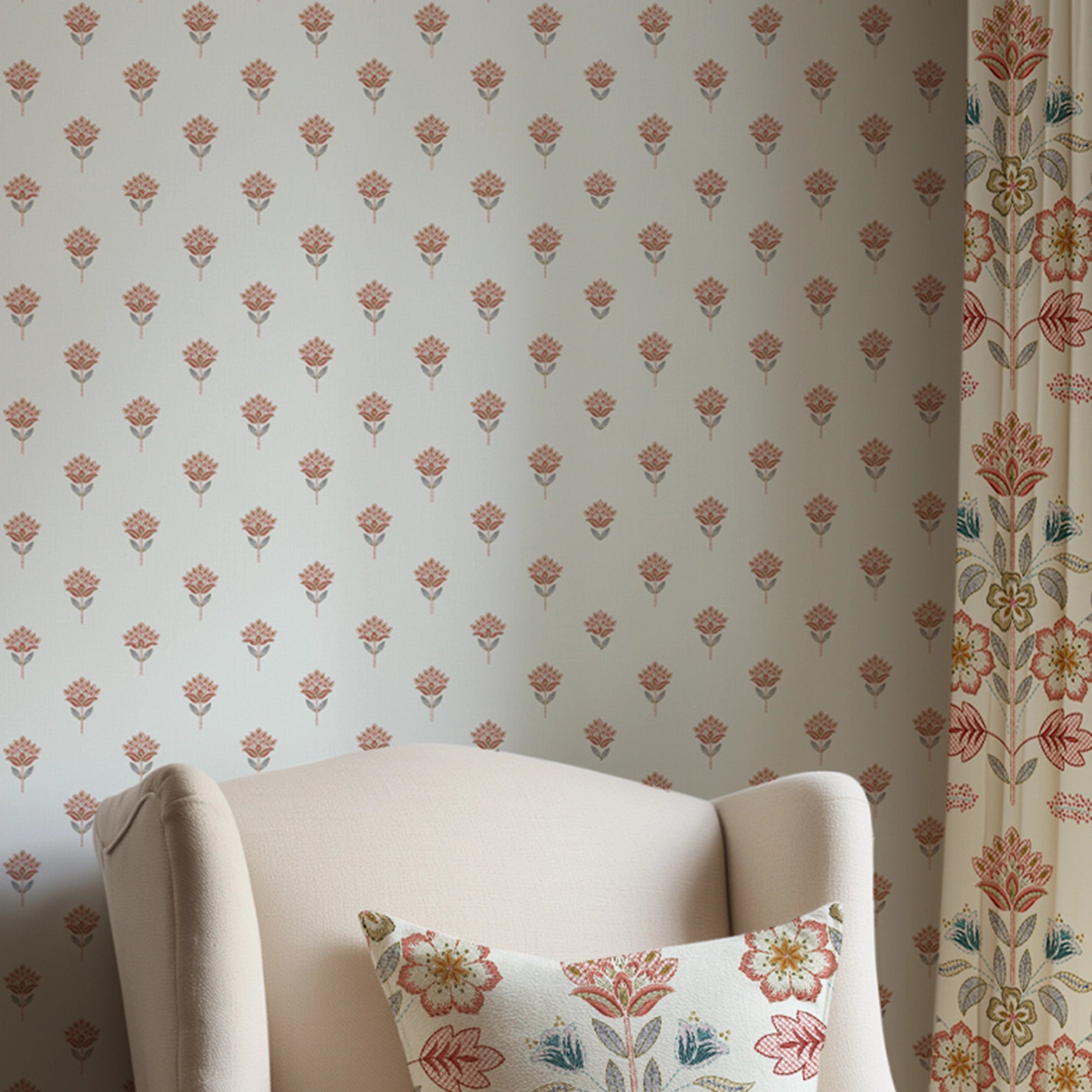 Small floral-patterned wallpaper with a matching pillow on a white chair.